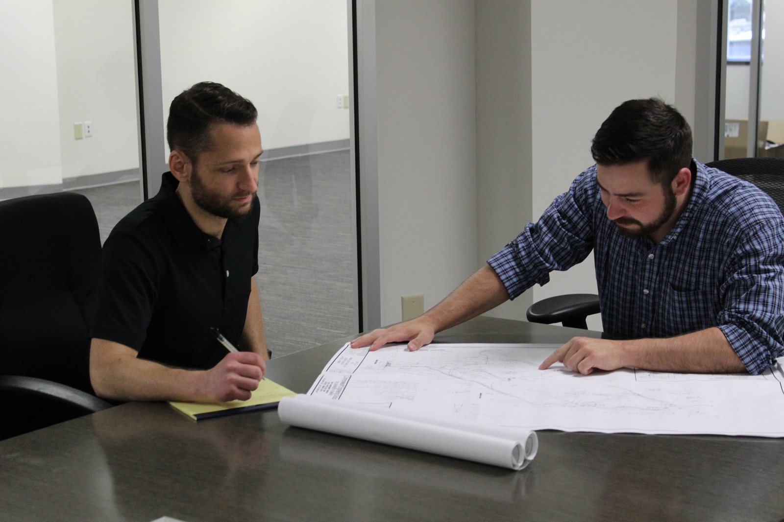 Two members of the 1850 Investments team reviewing site plans
